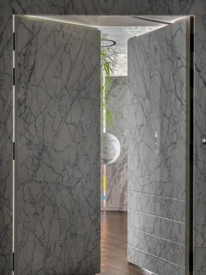 This isn't a wall, it's a door. We clad it in Grey Myst marble, making the entrance to the home virtually invisible. It sets the tone for a space full of surprises.