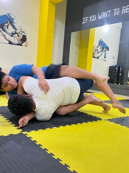 Two students work on their ground game. Learning to move and counter from different positions is a core part of our BJJ and wrestling curriculum.