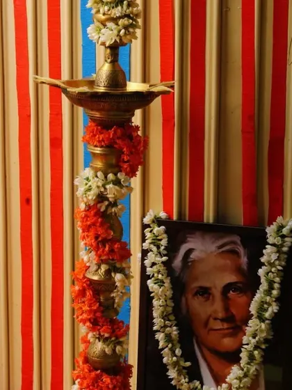 A traditional lamp and a portrait of Dr. Maria Montessori, honoring the roots of our philosophy.