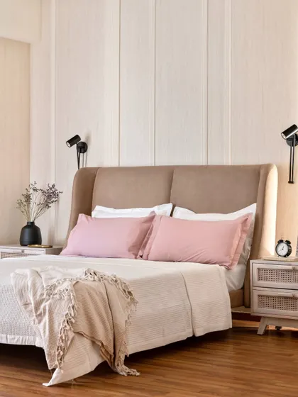 A bedroom should be a retreat. Here, we used a soft, muted color palette, layered textures with a custom upholstered headboard, and added fluted paneling to create a serene space that feels like a gentle embrace at the end of the day.