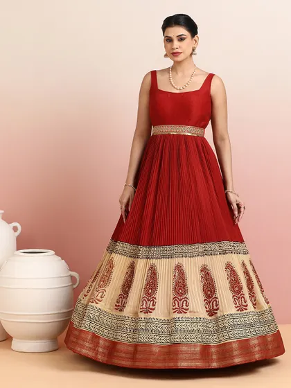 The full silhouette of the red and beige gown is both majestic and graceful, making it a perfect choice for a wedding reception or cultural event.