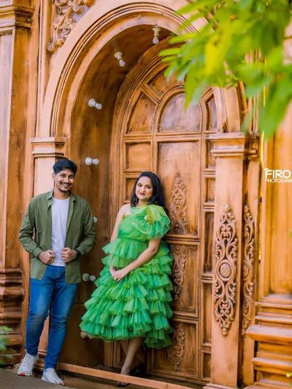 This mom-to-be looks radiant in a bright green tiered dress. We paired it with a more casual look for her partner to create a modern and stylish couple's maternity portrait against a rustic wooden door.