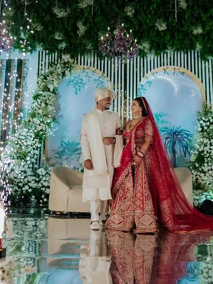 A grand reception stage with the couple surrounded by pyrotechnics. This wide shot captures the scale and opulence of the celebration.