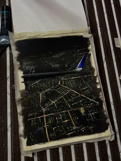 The painting in progress. I used a lot of black paint to create the night sky and then carefully added the glowing city grid.