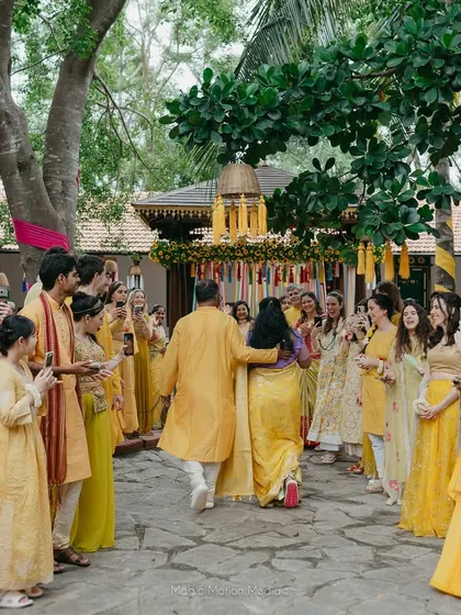The bride's family makes a grand entrance, walking in a procession for the Haldi ceremony.