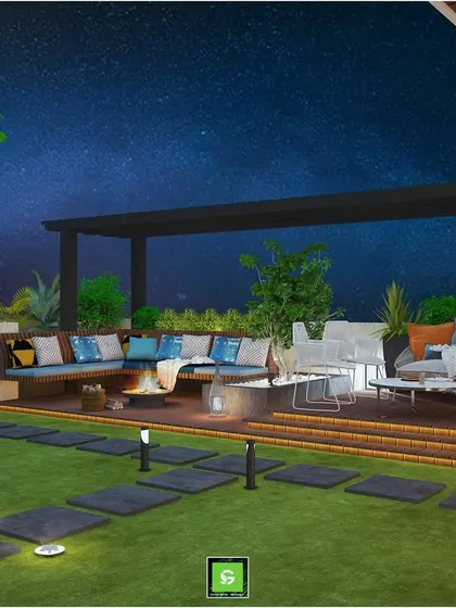 The same Gurugram terrace concept at night, with pathway lights and a fire pit creating a magical atmosphere under the stars.