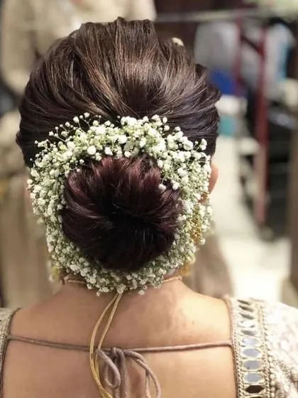 For those special occasions, I love creating hairstyles that are both messy and formal. This beautiful bun, adorned with delicate baby's breath flowers, is a timeless choice for weddings and festive events, offering an elegant yet modern look.
