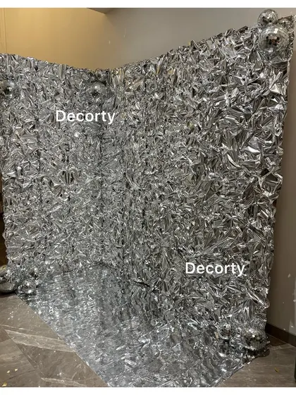 A versatile and glamorous foil backdrop that creates an incredible photo booth. This silver wall reflects light beautifully and is perfect for disco themes, anniversaries, or any chic party.