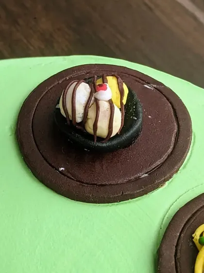 A tiny, tempting bowl of ice cream with chocolate sauce, sculpted from fondant. It's these small, delicious-looking details that make a cake extra special.