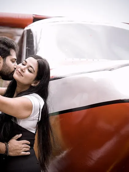 An intimate kiss by the airplane, combining romance with a sense of adventure.
