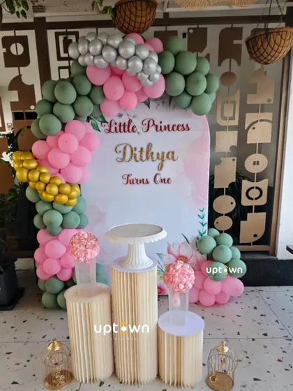 A simple and elegant princess theme with pink, green, and gold balloons.