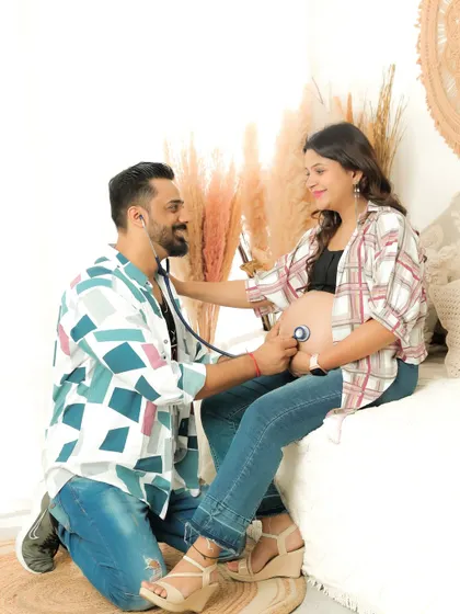 A playful and creative shot using a stethoscope to "listen" to the baby's heartbeat. It's a fun way to involve the dad-to-be in the maternity session.