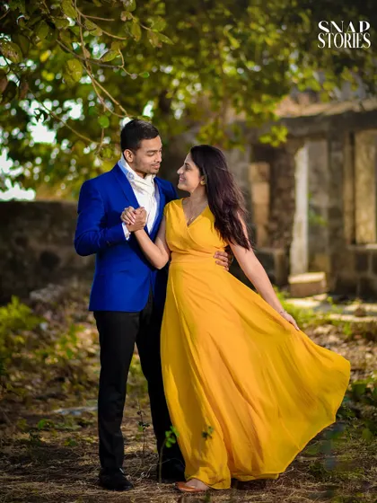 A simple walk in a rustic, natural setting can result in beautiful, heartfelt images. The vibrant colors of the couple's outfits pop against the greenery, creating a warm and romantic pre-wedding photograph.