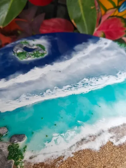 Another angle of the 'Aadya' resin art, showing the layers of waves and the rocky shore.