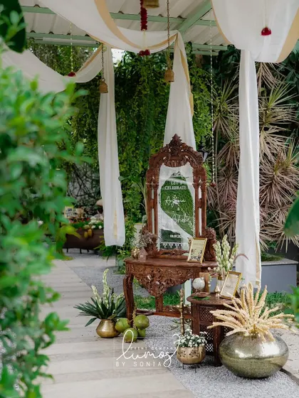 A closer look at the intricately carved wooden mirror and decor, reflecting the lush green surroundings and creating a stunning visual.