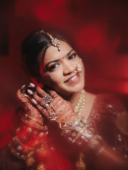 A beautiful close-up showing the intricate details of the bride's henna and jewelry. Her makeup is kept soft and glowing to complement the rich, traditional elements of her look.