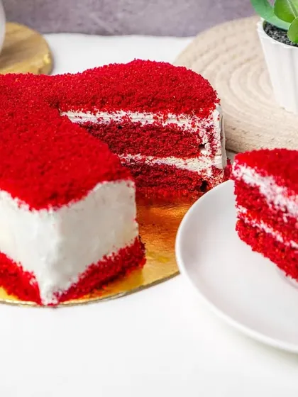 A red velvet heart cake with a slice placed separately to show the layers and texture.