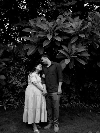 A beautiful black and white portrait of the couple standing under a large tree. The dramatic lighting and their loving gaze create a timeless and romantic image.