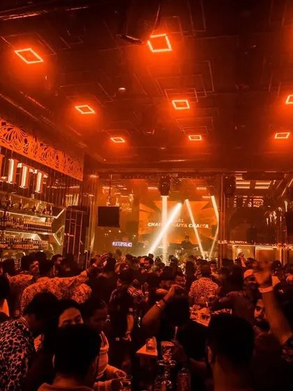 The view of a packed house at Club LITT in Kolkata, with the whole room glowing orange.