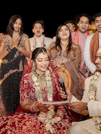 The bride and groom share a laugh with their friends and family during a wedding game. This photo is full of life, capturing the joy and community that make a wedding so special.