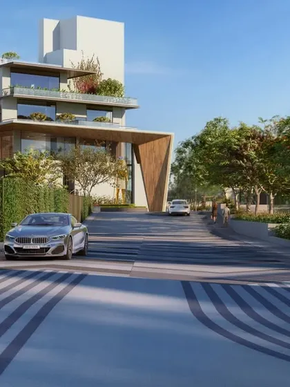 The entrance drive at Sattva Lumina is designed as a pleasant journey, lined with trees and leading to a modern clubhouse that acts as the community's focal point.