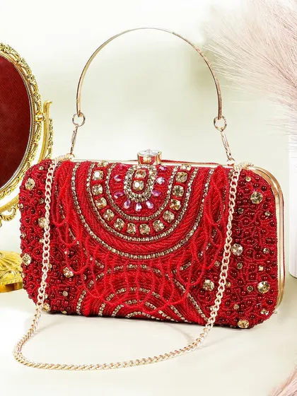 A glamorous, festive shot of a red beaded clutch. The gold mirror and rich red background give it a bridal or party ready feel, highlighting its intricate beadwork.