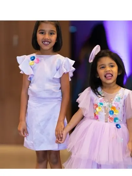 Sisterhood never clashes. Here are two sisters in our coordinated 'Charm' dress in lilac, one in a simple A-line cut and the younger one in a tiered tulle version.