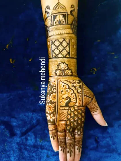 A single hand showing a detailed bridal design. This piece includes a peacock in a jharokha, intricate jaali work, and a lotus band at the wrist.