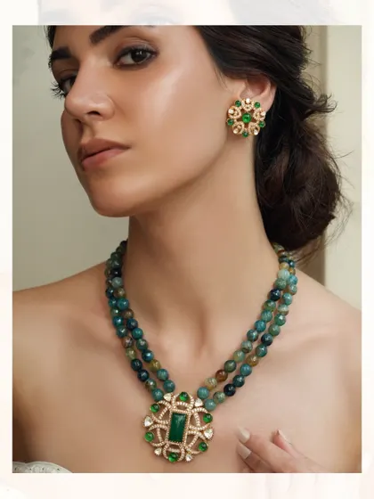 A statement piece with a large green pendant on a string of multi-hued green beads.