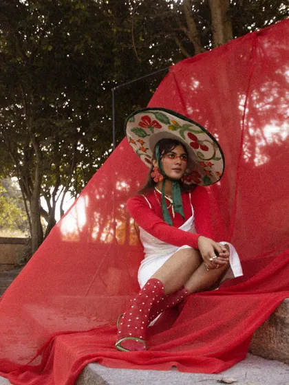 A seated pose from 'LUNA', showing the full outfit with accessories.