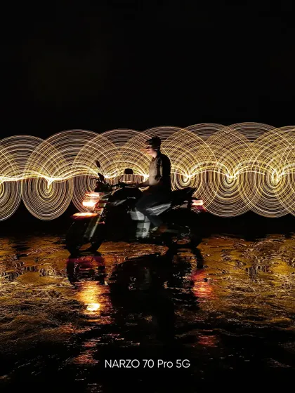 Another light painting experiment with the Narzo 70 Pro 5G. The circular patterns of golden light create a mesmerizing effect around the subject on the bike.