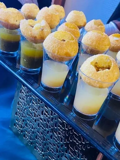 A stylish tray of our flavored Pani Puri Shots ready to be served at a corporate meet. We offer a variety of waters, including classic mint, tangy orange, and sweet and sour tamarind.