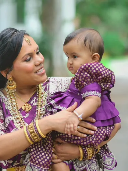 A close-up of Rashmi looking lovingly at her baby, her makeup looking natural and radiant.