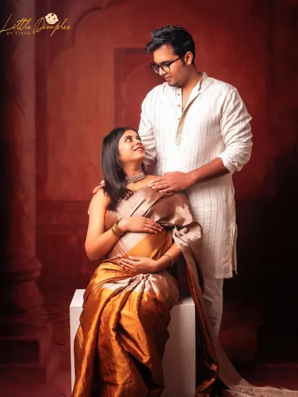 Saree stories are my favorite. This couple's portrait in traditional attire against a rich, textured red backdrop is a perfect example of a fine art maternity photo.