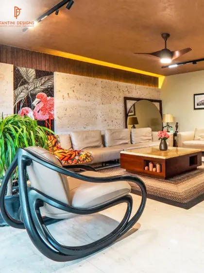 The sculptural rocking chair adds a unique design element to this living space, complementing the natural stone wall and modern furniture.
