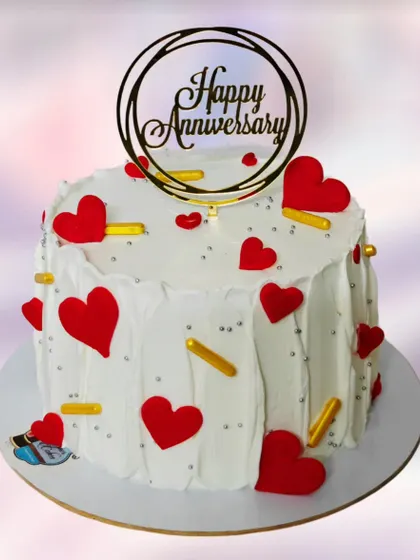 A simple yet festive anniversary cake covered in red hearts. The clean white base makes the red hearts pop, creating a classic symbol of love.