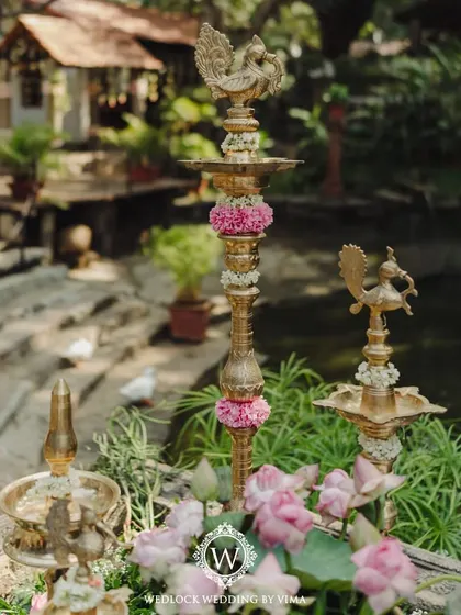 Details from a minimal and serene wedding setup. The decor features serene lotuses, traditional brass lamps, and other meaningful elements that reflect the couple's vision.
