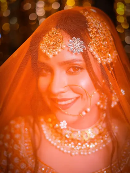 A happy, smiling portrait through the veil. The sheer fabric creates a soft-focus effect that is very flattering.