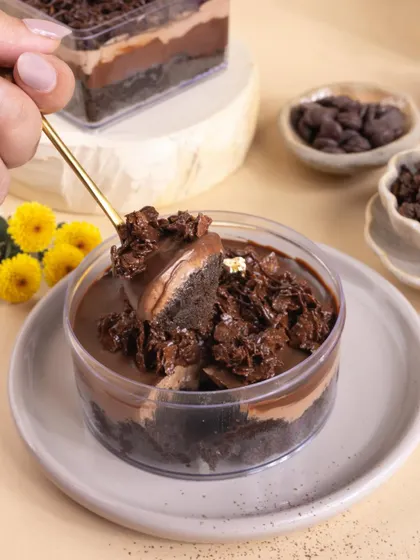 An action shot showing a spoonful of the chocolate tub dessert, designed to make you crave a bite and highlight its gooey texture.