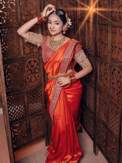A full-length view of this stunning red silk saree. I love how the gold checkered blouse with detailed sleeves adds a touch of classic charm to the overall bridal attire.