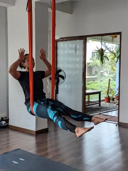 The playful side of practice. A moment of laughter and lightness while exploring movement in the aerial hammock. It's not just a workout; it's a joyful experience.