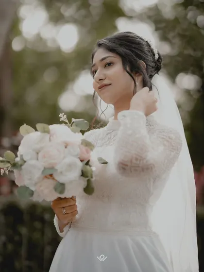 A beautiful outdoor portrait of a Christian bride holding her bouquet, with a soft, natural background.