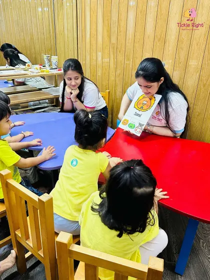 A trainer uses a large flashcard to teach a group of children, who are all listening intently. Our methods are designed to hold the attention of even the youngest learners.