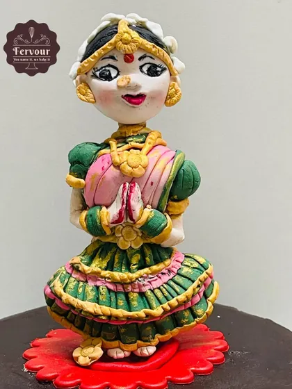 A close-up of the hand-sculpted Bharatnatyam dancer topper. Every detail, from the costume to the jewelry, is carefully crafted from fondant.