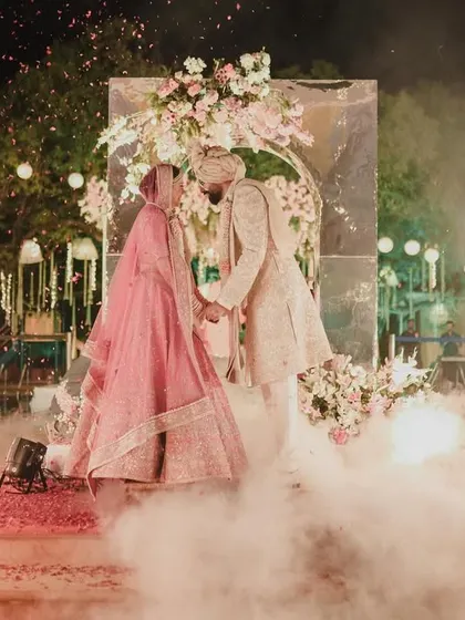 A dreamy and dramatic Varmala exchange, with the couple surrounded by smoke and sparklers, creating a truly cinematic moment.