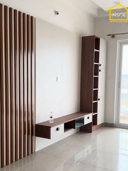 A clean and modern TV unit design featuring a combination of wood-grain laminate and white cabinets, with vertical fluted paneling adding texture and visual interest.
