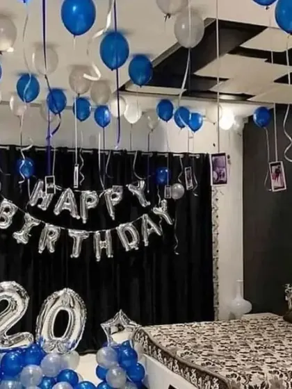 A 20th birthday room decoration in blue and silver, with hanging photos for a personal touch.