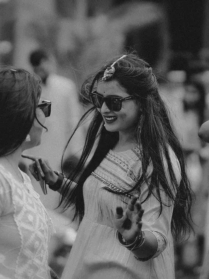 A cool black and white shot of the bride and a friend dancing with sunglasses on, capturing the fun vibe of the Haldi.