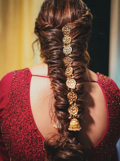 A detailed shot of the beautiful fishtail braid with gold coin accessories, created for Ishita's engagement.