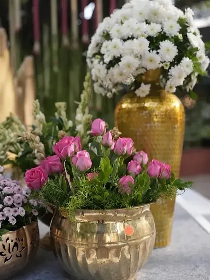 A close-up of beautiful floral arrangements in textured brass pots, showcasing the quality and freshness of the flowers we use.